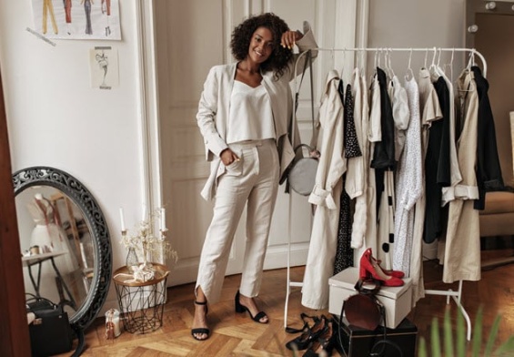 fulllength-portrait-stylish-darkskinned-curly-woman-white-pants-jacket-top-posing-dressing-room-young-lady-leans-hanger.jpg