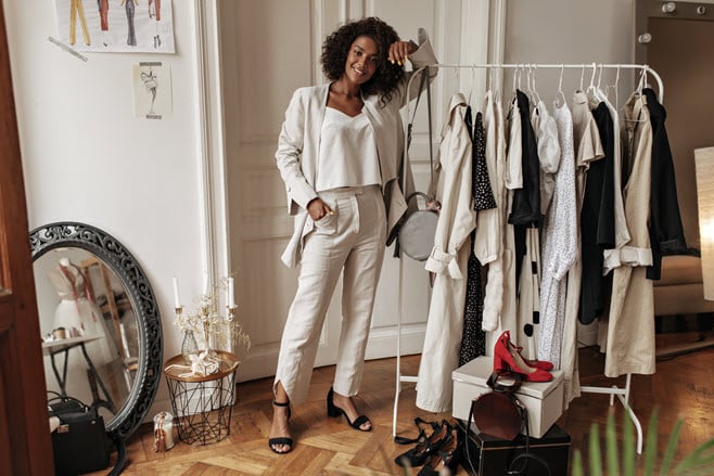 fulllength-portrait-stylish-darkskinned-curly-woman-white-pants-jacket-top-posing-dressing-room-young-lady-leans-hanger.jpg